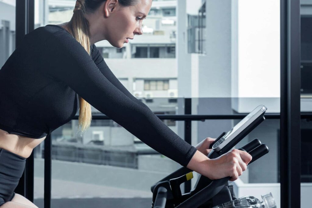 Une femme fait une séance de cyclisme en salle